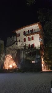 stary budynek z czerwonymi drzwiami i oknami w nocy w obiekcie La Berlera - Riva del Garda w mieście Riva del Garda