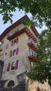 a tall building with purple windows and a balcony at La Berlera - Riva del Garda in Riva del Garda