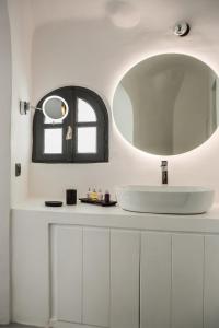 a bathroom with a white sink and a mirror at Sun Rocks Boutique Hotel in Firostefani