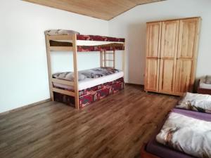 a bedroom with two bunk beds and a wooden floor at Agro Zula in Hrabušice