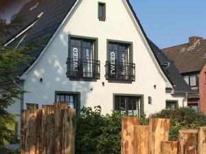 a house with black windows and a black roof at Hotel TWEED in Sankt Peter-Ording