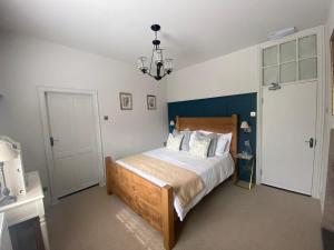 a bedroom with a bed and a chandelier at The Family Tree in Whatstandwell +62 photos