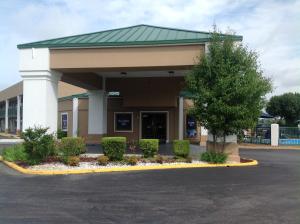 a building with a tree in front of it at Hallmarc Inn & Suites of West Memphis in West Memphis