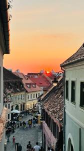 a group of people walking down a city street at sunset at Pensiunea Cardinal in Sibiu