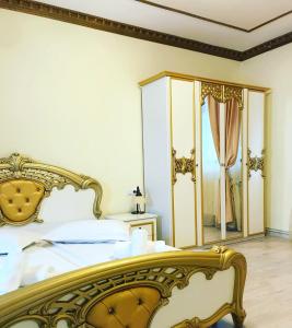 a bedroom with a gold bed and a mirror at Pensiunea Cardinal in Sibiu