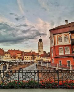 Blick auf eine Stadt mit einem Uhrturm und Gebäuden in der Unterkunft Pensiunea Cardinal in Sibiu