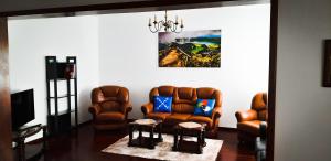 a living room with two leather chairs and a television at Adamas Bed & Breakfast in Ponta Delgada