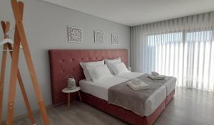 um quarto com uma cama grande e uma cabeceira vermelha em Villa Regadio na Covilh mais 37 fotografias