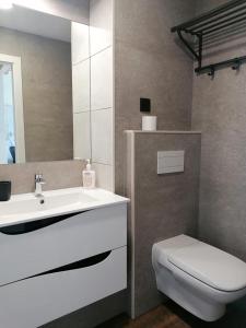 a bathroom with a white sink and a toilet at A Casinha in Caldas da Rainha +10 photos