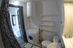 a bathroom with a white toilet and a washing machine at Уютная квартира со свежим ремонтом in Odesa