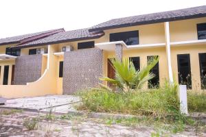 a house with a palm tree in front of it at OYO 3438 Pasir Padi Inn Syariah in Kebinti