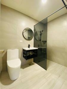 a bathroom with a toilet and a sink and a mirror at Yin Shan Hotel in Zhongzheng