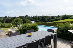 a patio with a table and chairs and a swimming pool at La villa de Spa in Spa