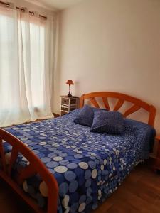una camera da letto con un piumone bianco e blu su un letto di V.V JUANA a Valverde