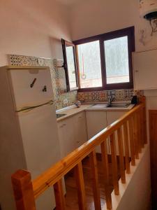 a kitchen with a refrigerator and a sink and a staircase at V.V JUANA in Valverde