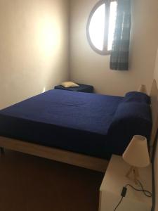 a bedroom with a blue bed and a window at Casetta Mondello in Mondello