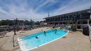 - une grande piscine avec des personnes dans l'établissement Sandbox Motel, à Wildwood