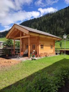 domek z bali na środku pola w obiekcie Schlosswirt Chalets & Apartments w mieście Großkirchheim