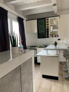 una cucina con armadi bianchi e piano di lavoro bianco di Appartamento confortevole a Cagliari