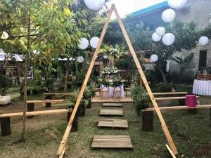 una struttura in legno con tavoli e sedie in un giardino di Nuwono Tasya Syariah a Bandar Lampung Altre 37 foto