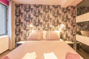 een slaapkamer met een bed en een muur bedekt met behang bij BELENA GOLD COAST in Beaune