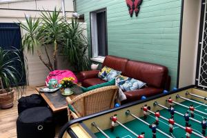 a patio with a couch and a table and a pool table at BELENA GOLD COAST in Beaune