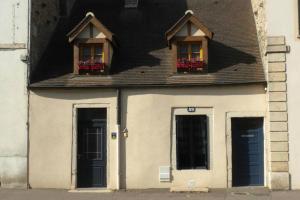 un edificio con due finestre e due porte con fiori di BELENA GOLD COAST a Beaune