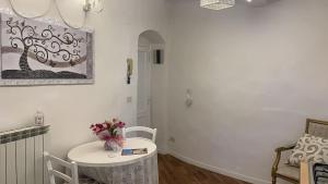 una stanza bianca con tavolo e vaso di fiori di Appartamento incantevole nel centro di Arezzo ad Arezzo