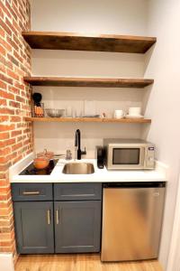 a kitchen with a sink and a microwave at The Queen Suite at Prince Street Inn in Alexandria