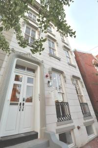 Casa blanca con puerta y ventanas blancas en The Queen Suite at Prince Street Inn, en Alexandria