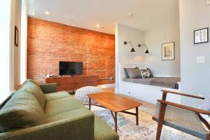 a living room with a couch and a brick wall at The Royal Suite at Prince Street Inn in Alexandria
