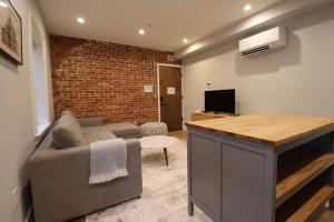 a living room with a couch and a brick wall at The Old Town Suite at Prince Street Inn in Alexandria