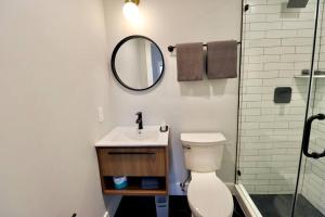a bathroom with a toilet and a sink and a mirror at The Fairfax Suite at Prince Street Inn in Alexandria