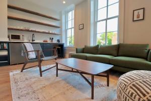 Una sala de estar con un sofá y una mesa de café. en 9 Suites at Prince Street Inn, en Alexandria