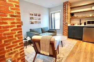 a living room with a couch and a brick wall at The Jefferson Suite at Prince Street Inn in Alexandria