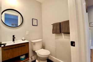 a bathroom with a toilet and a sink and a mirror at The Jefferson Suite at Prince Street Inn in Alexandria