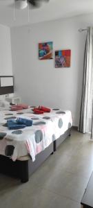 a bed in a white room with avertisement at Apartamento Jardines del Campanario in Torrox