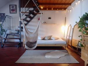 eine Hängematte in einem Zimmer mit einem Bett und einer Treppe in der Unterkunft BORGO DORA 1 in Turin