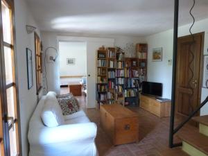 - un salon avec un canapé blanc et une télévision dans l'établissement Casa Jacaranda, à Monteverdi Marittimo