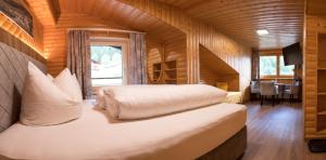 a bedroom with two beds in a wooden cabin at Sonnenhang Montafon in Sankt Gallenkirch
