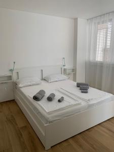 duże białe łóżko w białym pokoju z dwoma elementami w obiekcie Studio Apartment Zara w mieście Zadar