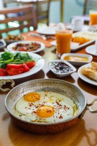 a table with eggs in a pan and plates of food at SUENA HOTEL Çeşme in Çeşme
