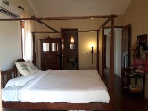 una camera con un grande letto con struttura in legno di Casa Arya Villa a Sinquerim
