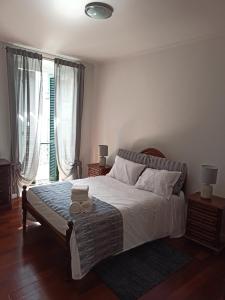 um quarto com uma cama e uma grande janela em Alojamento Fernandes em Horta