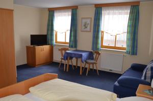 a hotel room with a bed and a table and chairs at Wildwiesenhof in Miesenbach