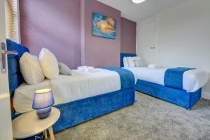 two beds in a room with blue and white at The Quirky Cottage in Leicester