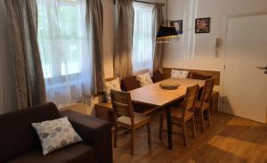 a dining room table with chairs and a couch at Apartmány NETA Velké Karlovice, Polanský Dvůr in Velké Karlovice