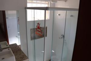 a bathroom with white cabinets and a window and a sink at Chalés Capitólio in Capitólio