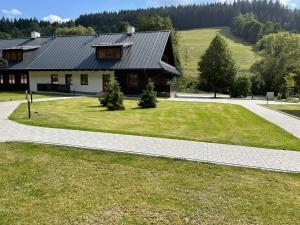a house with a large yard in front of it at Apartmány NETA Velké Karlovice, Polanský Dvůr in Velké Karlovice