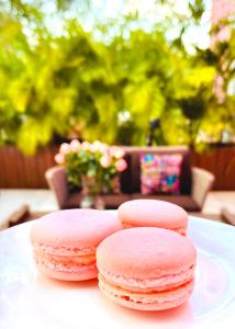 four pink cookies on a plate on a table at Rosas & Xocolate Boutique Hotel and Spa Merida, a Member of Design Hotels in Mérida